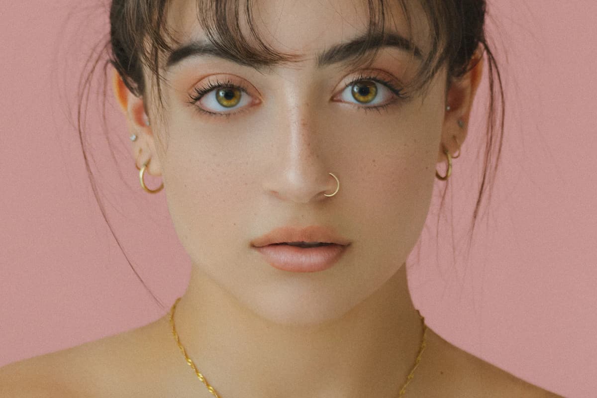 Female model's face framed by curly hair, illustrating how to identify your face shape from proportions